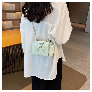 Detail of mint green quilted mini bag with silver chain and floral zipper charm