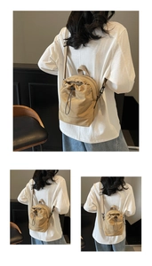 Detail view of khaki canvas mini drawstring bag showing adjustable strap and texture
