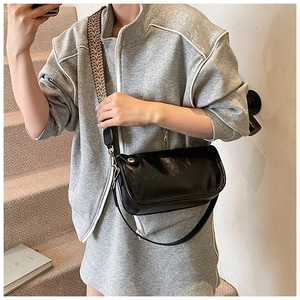 Sac à bandoulière noir brillant avec sangle tissée géométrique et aspect cuir