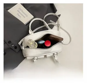 Internal capacity of the white Boston bag showing space for perfume and lipstick