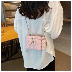 Pink quilted crossbody bag with silver chain strap shown as a stylish back view on model
