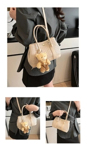 Detail of woven cream bucket bag with detachable strap and cute plush bear charm