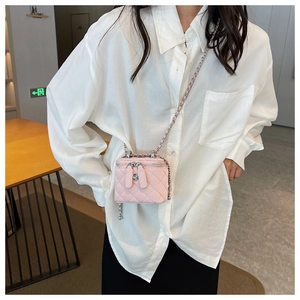 Detailed view of pink quilted leather mini crossbody bag worn with white shirt