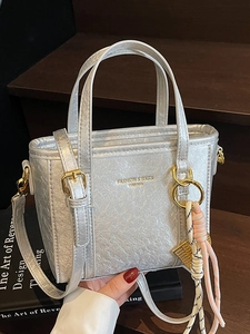 Silver bucket bag with metallic texture, gold hardware and decorative tassel pendant
