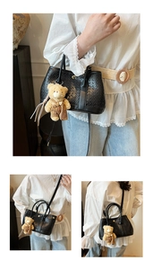 Detail of black woven texture handbag featuring a cute bear pendant and golden clasp