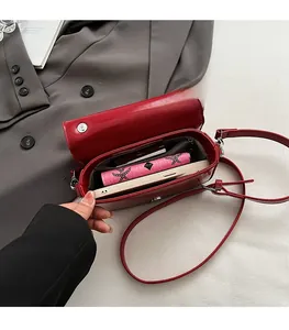 Vue détaillée de l'intérieur du sac rouge verni montrant l'espace pour portefeuille et mobile