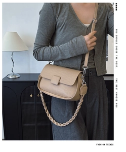 Detail of beige litchi grain crossbody bag with twisted short strap and square buckle