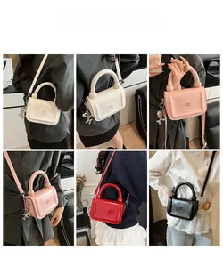 Vue détaillée de mini sacs bandoulière en quatre couleurs avec poignées anneau et breloques