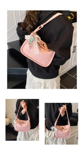 Detailed view of pink crossbody bag with litchi grain texture and lace bow decor