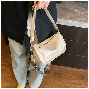 Détail du sac en similicuir blanc cassé avec une large bandoulière en jacquard élégante