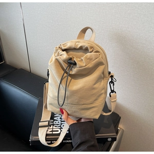 Detail of beige nylon drawstring crossbody bag showing fabric texture and adjustable strap