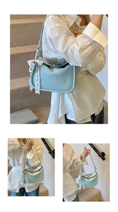 Detail of light blue lychee pattern leather handbag with lace bow and cartoon pendant