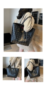 Detailed view of black monogram tote bag with gold hardware and interior red lining