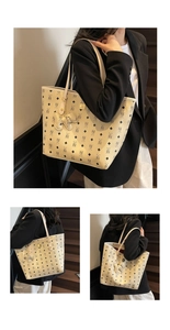 Detail of large cream tote bag with bear monogram pattern and textured leather surface