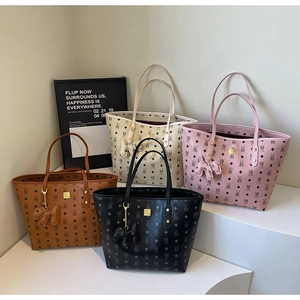 Classic monogram tote bags in multiple colors with cute dog charms on a display stand