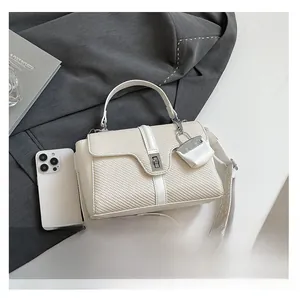 Detailansicht der gewebten quadratischen Handtasche mit breitem Schultergurt