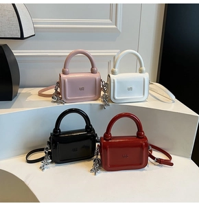 Détails de quatre sacs à main colorés en cuir verni avec des charms chien de baudruche