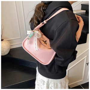 Pink lychee leather bag detail with gold clasp and white lace bow accessory