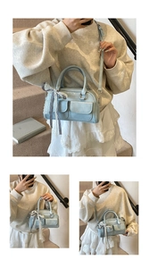 Detail of light blue bow handbag with checkered lace accents and front pockets