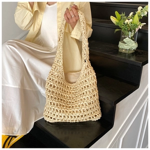 Close-up of beige hollow-out woven straw tote bag with fabric lining for beach vacation