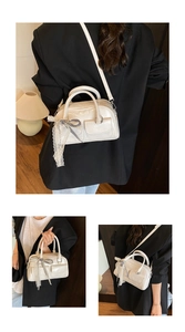 Detail of cream glossy leather bowling bag with lace ribbons and side bow accents