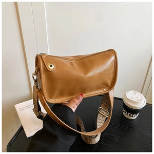 Détail du sac bandoulière en similicuir marron avec large bandoulière tissée ethnique