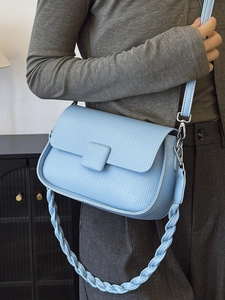 Light blue faux leather crossbody bag with woven texture and dual shoulder straps