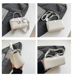 Detailansicht der beigen Textur-Handtasche mit gemustertem breitem Gurt und Metallschloss