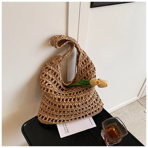 Detail of hand-woven straw tote bag with large hollow mesh texture and natural fiber finish
