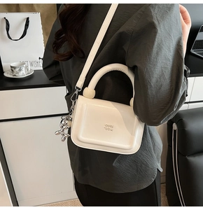 Vue détaillée du sac blanc avec pendentif chien ballon argenté et logo en relief chic