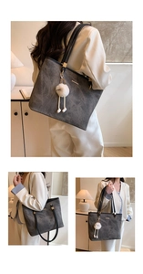 Macro detail of dark grey tote bag with vintage texture and monster plush pendant