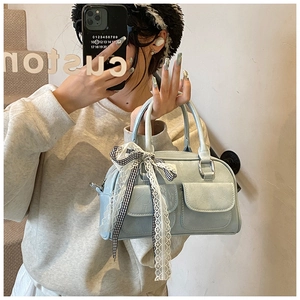 Sac Boston bleu clair avec deux poches à rabat et un nœud décoratif en ruban élégant
