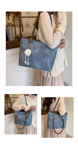 Detail of blue textured tote bag with brown straps and cute white plush ball charm