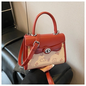 Dettaglio della borsa rossa e beige con stampe di orsetti e chiusura in metallo