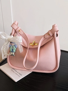 Pink lychee grain leather pillow bag with gold clasp and pearl bow charm detail