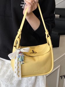 Minimalist yellow lychee leather pillow bag with metal twist lock and cute cartoon charm