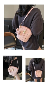 Detail of pink monogram bucket bag with cute bear charm and classic metal clasp closure