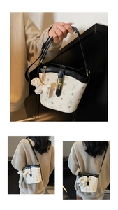 Close-up of bucket bag with bear print pattern, black leather trim and golden clasp