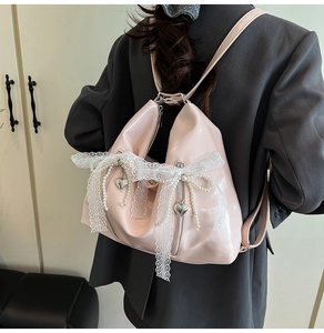 Pink glossy patent leather backpack with lace bows, pearl charms and heart-shaped zippers