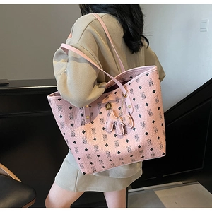 Pink tote bag detail with cartoon bear print, textured leather surface and shoulder strap