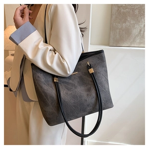 Detail of gray matte tote bag showing high-capacity design and gold metallic hardware