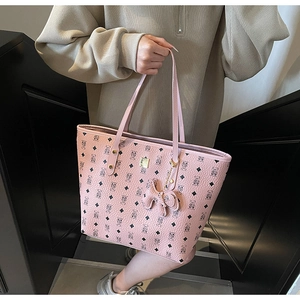 Pink tote bag with bear pattern print, gold hardware, and matching plush bear keychain charm