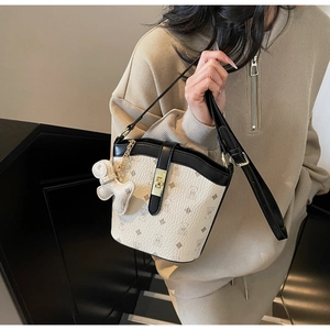Detail of trendy bucket bag with bear print, gold buckle and adjustable strap