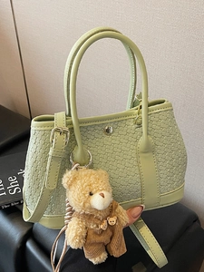 Sage green woven bucket bag with top handles and cute teddy bear charm pendant