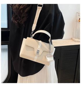 Detail der beigen gewebten Handtasche mit weißem Lederbesatz und Jacquard-Gurt