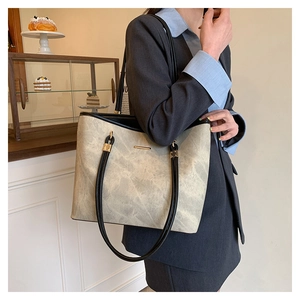 Minimalist cream leather tote bag with black straps and gold hardware for daily work