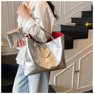 Close-up of silver tote bag with metallic wrinkled texture and vibrant red inner lining