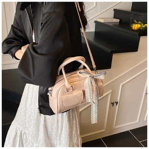 Sac Boston rose en cuir brillant avec un nœud en dentelle à carreaux sur la poignée