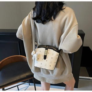 Detail view of stylish crossbody bucket bag with cartoon bear pattern on model