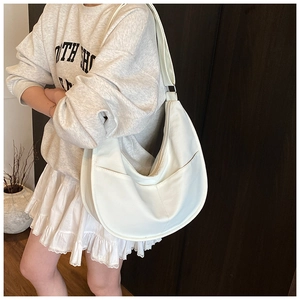 Detail shot of a white half-moon Hobo bag featuring premium textured leather and zip closure